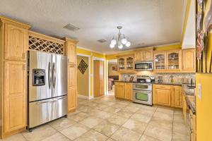 eine Küche mit Holzschränken und einem Kühlschrank aus Edelstahl in der Unterkunft Cozy Home in Heart of Tampa with Lanai and Pool! in Tampa
