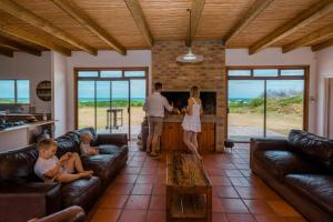 a group of people in a living room with furniture at The Log House in Pearly Beach
