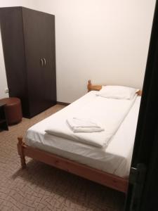 Una cama con dos toallas blancas encima. en Hotel Liani, en Lovech