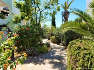 a garden with flowering plants and palm trees at Apt T2 Praia São Rafael Hibiscus 18A - Albufeira, Algarve in Albufeira