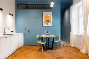 a kitchen with blue walls and a table and chairs at Wonderful in Krakow