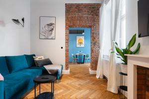 a living room with a blue couch and a brick wall at Wonderful in Krakow