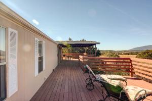 una terraza con sillas y mesas en una casa en Peaceful Sandia Park Retreat with Deck and Views! en Sandia Park