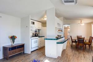a kitchen and dining room with white cabinets and a table at Peaceful Sandia Park Retreat with Deck and Views! in Sandia Park