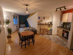 un soggiorno con tavolo e cucina di Ton Petit Studio - Le 62 - Coeur de Ville a Mulhouse