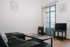 a living room with a couch and a coffee table at Le Refuge du Clocher in Laroque-des-Albères