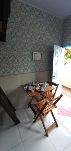 Kitnet Barra de Ibiraquera في بارا دي إيبيراكويرا: طاولة وكراسي خشبية في الغرفة