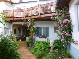 a house with a balcony and flowers in the yard at Stieglerhof KG in Illmitz
