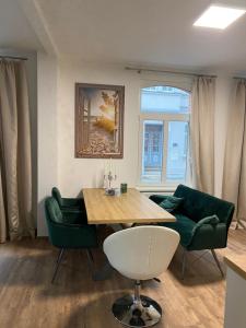 sala de estar con mesa y 2 sillas verdes en Schwartz GmbH en Greiz