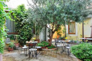 a garden area with tables, chairs, and plants at Relais Le Clarisse in Rome