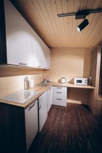 kuchnia z białymi szafkami i drewnianą podłogą w obiekcie Space Place w mieście Jabłonica