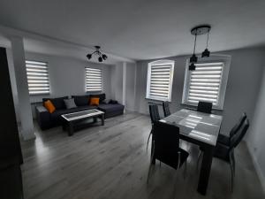 ein Wohnzimmer mit einem blauen Sofa und einem Tisch in der Unterkunft Apartament "U Kasi i Jakuba" in Szklarska Poręba