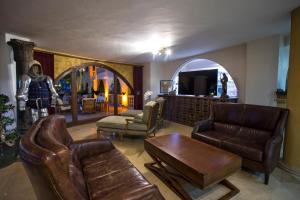 a living room with leather furniture and a tv at Le Chateau Lambousa in Kérynia