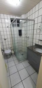 y baño con ducha de cristal y aseo. en Apartamento na praia de Bombas Edifício Umuarama bloco B, en Bombinhas
