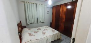 1 dormitorio pequeño con 1 cama y armario de madera en Apartamento na praia de Bombas Edifício Umuarama bloco B, en Bombinhas