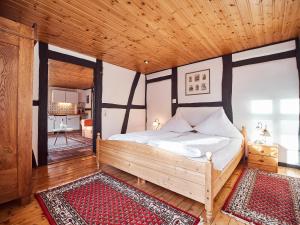 ein Schlafzimmer mit einem Bett und einer Holzdecke in der Unterkunft Appartementhotel Blomberger Hof in Blomberg