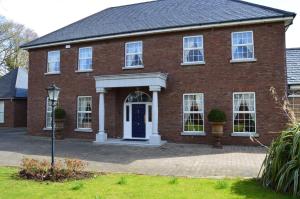 una casa de ladrillo rojo con puerta azul en Beechwood Country House, en Malahide