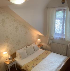 sypialnia z łóżkiem z 2 lampami i oknem w obiekcie Hotel Penzion Trámky w mieście Vikýřovice +37 zdjęć