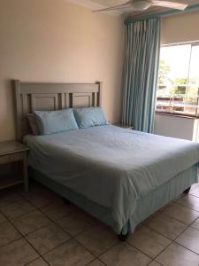 a large bed in a bedroom with a window at 104 Santana Resort, Margate Beach in Margate
