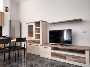 salon z telewizorem i stołem z krzesłami w obiekcie APARTAMENTOS La PEÑA C w mieście La Guancha