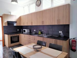 kuchnia ze stołem, zlewem i zegarem w obiekcie APARTAMENTOS La PEÑA C w mieście La Guancha