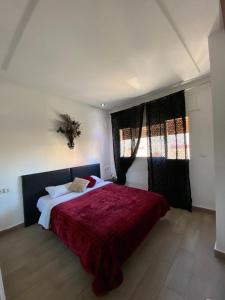 sypialnia z dużym łóżkiem i czerwonym kocem w obiekcie Furnished apartments Family only w mieście Tanger