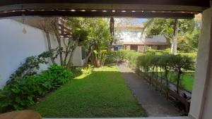an outside view of a yard with grass and trees at Casa Boutique Peró in Cabo Frio