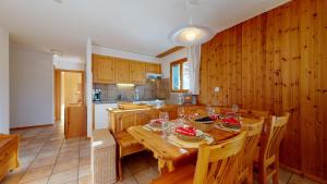 eine Küche und ein Esszimmer mit einem Holztisch in der Unterkunft Les Crêtes SUNNY & CENTER apartments by Alpvision Résidences in Veysonnaz