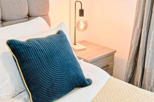ein blaues Kissen auf einem Bett in einem Schlafzimmer in der Unterkunft 4-Bed - 2 Bath - Off-Road parking - Ideal for Contractors in Swansea + 28 Fotos