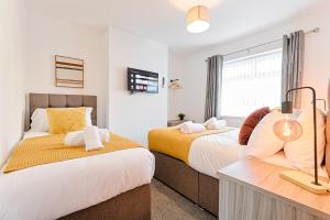 ein Schlafzimmer mit zwei Betten und einem Fenster in der Unterkunft 4-Bed - 2 Bath - Off-Road parking - Ideal for Contractors in Swansea