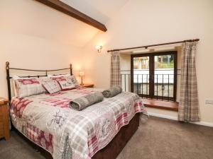 a bedroom with a bed and a window at Red Deer Cottage in Minehead