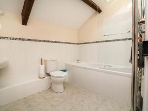 a bathroom with a toilet and a tub and a sink at Red Deer Cottage in Minehead +20 photos