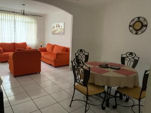 uma sala de estar com uma mesa e um sofá em Room 4 rent em San Salvador