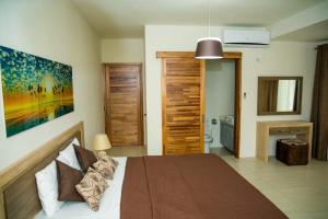 a bedroom with a large bed and a bathroom at Entire Luxury 3 BR condo for rent - Flic-en-Flac - Close to Beach in Flic-en-Flac