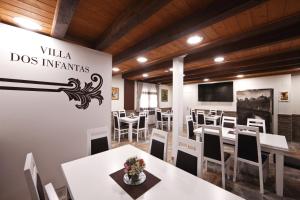 a dining room with white tables and chairs at VILLA DOS INFANTAS in Puebla de Sanabria