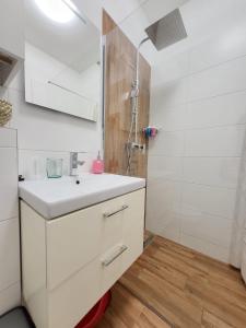 a white bathroom with a sink and a shower at Veľký apartmán 3 in Karlova Ves