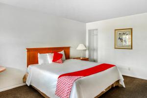 a bedroom with a large bed with red and white pillows at OYO Gateway Motel Las Vegas North Strip Fremont St Area in Las Vegas