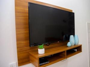 a large flat screen tv on a wooden wall at Pousada encanto do mar, Nova caraiva-Ba in Porto Seguro