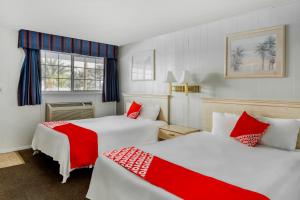a hotel room with two beds with red accents at OYO Gateway Motel Las Vegas North Strip Fremont St Area in Las Vegas