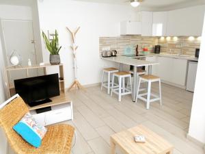 uma sala de estar com uma cozinha com uma mesa em Le Piade, confort moderne, vue dégagée, clim, ascenseur, WiFi em Sète