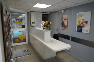 a cashier counter in a store with flowers on the wall at Premiere Classe Deauville Touques in Deauville