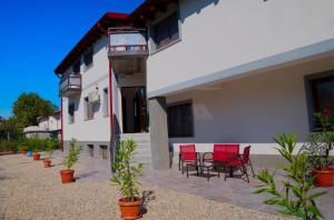 a group of red chairs sitting outside of a building at VILA VANESSIMO in Eforie Sud