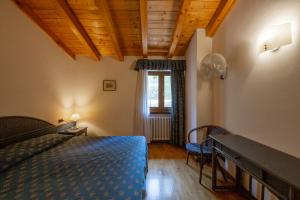 a bedroom with a bed and a desk and a window at Residence Castelli in Brenzone sul Garda