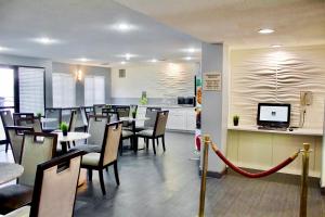 a restaurant with tables and chairs and a kitchen at Quality Inn & Suites Irving DFW Airport South in Irving