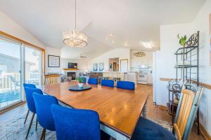comedor y sala de estar con mesa de madera y sillas azules en Sea Sun Greetings, en Kitty Hawk