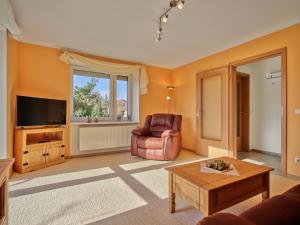 a living room with a chair and a television at Gemütliche Ferienwohnung in ländlicher Lage in Riesa