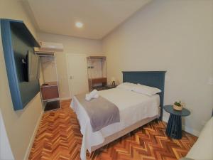 a bedroom with a large white bed and a wooden floor at Paranaguá Lodge in Paranaguá