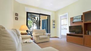 a living room with a tv and a couch and a chair at Ana1 - Llafranc in Llafranc