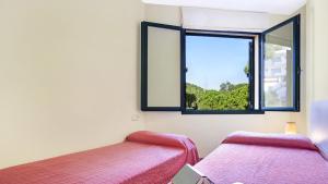 a room with two beds and a window at Ana1 - Llafranc in Llafranc
