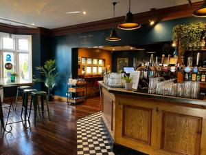 a bar in a restaurant with a counter and stools at The Admiral Cunningham Hotel in Bracknell